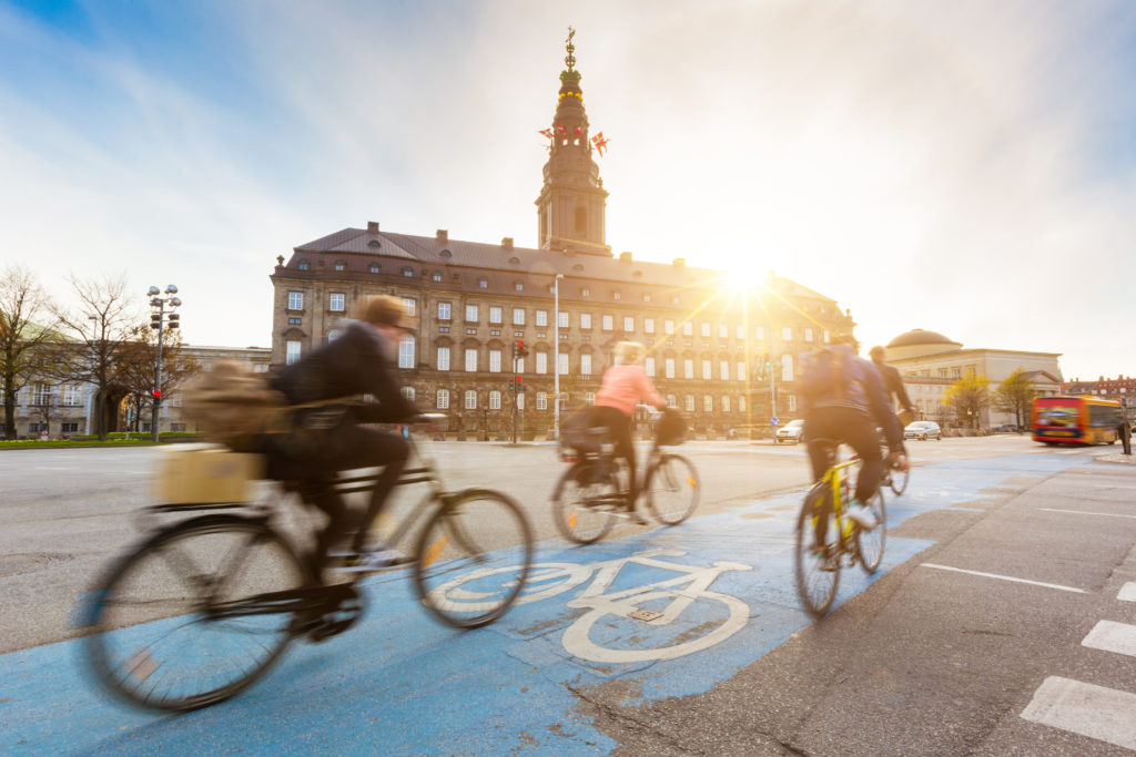 Cyklister på cykelsti i københavn, med Christiansborg i braggrunden.